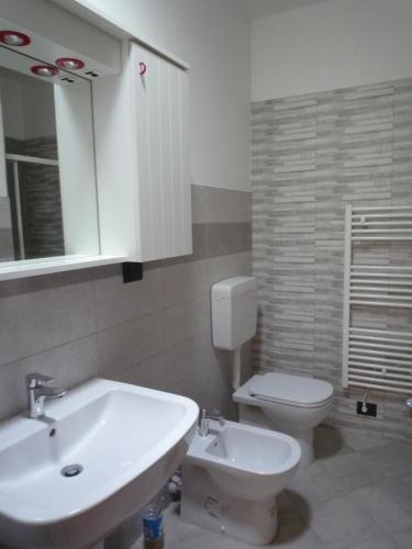 a bathroom with a sink and a toilet and a mirror at La Vigna del Parroco-2- in Serralunga d'Alba