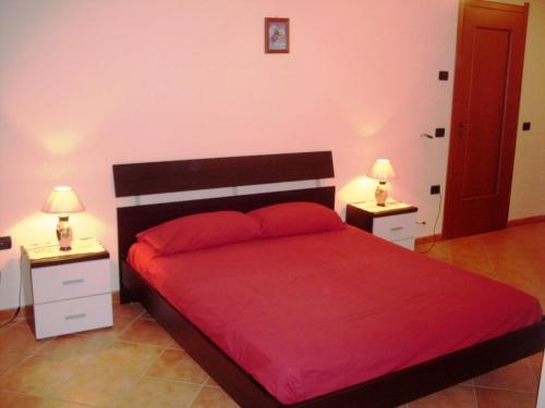 1 dormitorio con 1 cama roja y 2 mesitas de noche en Tropea Zambrone en Zambrone