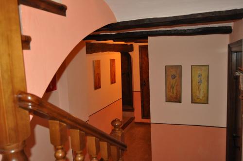 a staircase in a house with paintings on the walls at Hotel la Casa del Abuelo in Albarracín