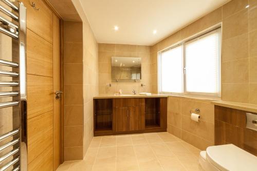 a bathroom with a sink and a toilet and a window at Biarritz Hotel in St. Brelade