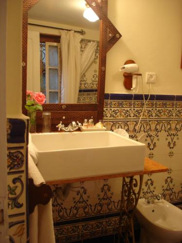 a bathroom with a sink and a mirror and a toilet at El Reducto in Tetouan