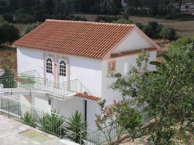 una piccola casa bianca con tetto arancione di Boulevard Panorama Suites a Ayia Evfimia