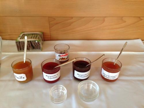 four jars of jam with spoons in them on a table at Frühstückspension Rüf in Au im Bregenzerwald