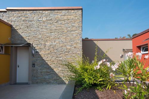 a brick wall with a white door and some plants at ReBi Village in Imperia