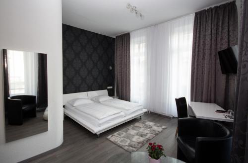 sala de estar con cama blanca y escritorio en Hotel Luisenhof, en Wiesbaden