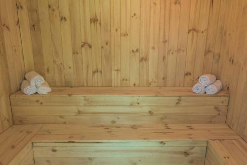 a wooden sauna with rolled towels on a wooden shelf at El Cano in Guaillabamba