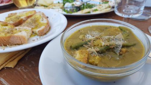 a bowl of soup on a table with plates of food at La Luna nel Pozzo in Riofreddo