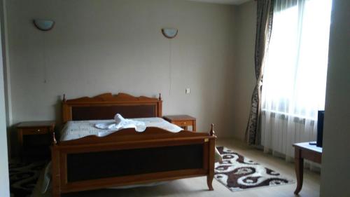 a bedroom with a wooden bed and a window at Guest House Raffe in Dobrinishte