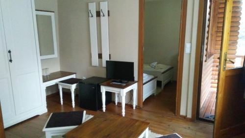 a living room with a television and a table at Guest House Raffe in Dobrinishte