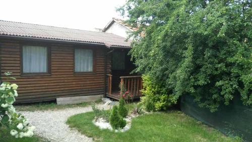 a log cabin with a yard in front of it at Guest House Raffe in Dobrinishte