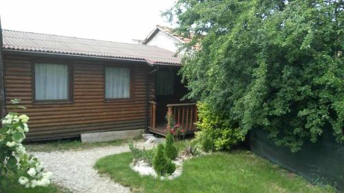 a log cabin with a garden in front of it at Guest House Raffe in Dobrinishte