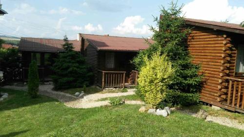 a log cabin with a yard in front of it at Guest House Raffe in Dobrinishte