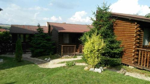 a log cabin with a yard in front of it at Guest House Raffe in Dobrinishte