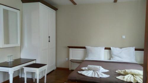 a bedroom with a bed with two pillows on it at Guest House Raffe in Dobrinishte