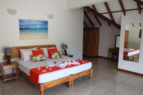 1 dormitorio con 1 cama con manta roja y blanca en Grann Kaz Guest House, en Anse a La Mouche