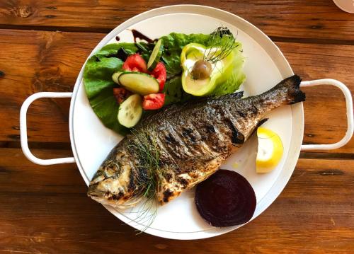 um prato de comida com peixe e legumes em Sagini Boutique Hotel em Loutra Edipsou
