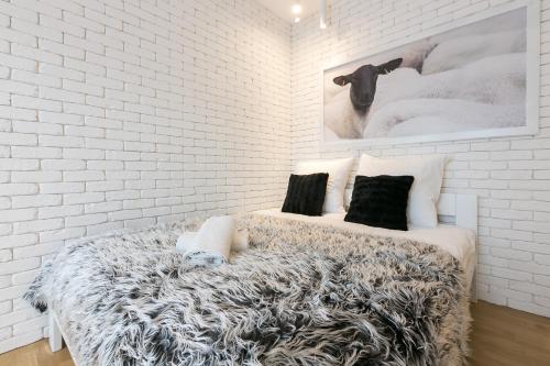 a bedroom with a white brick wall and a bed at VIP Apartamenty Stara Polana 2 in Zakopane