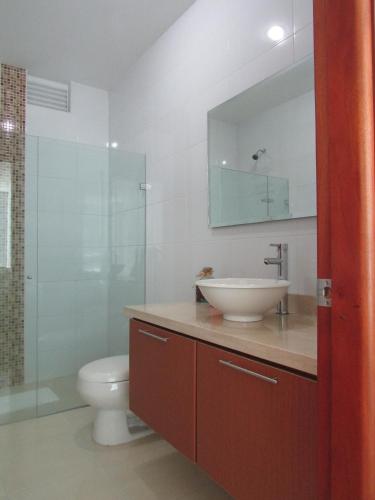 a bathroom with a sink and a toilet and a mirror at Costa Azul Suites 1002 in Santa Marta