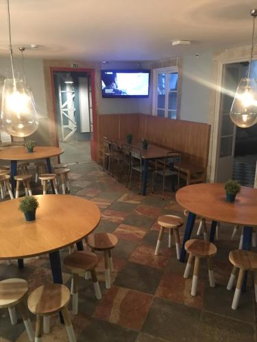 a restaurant with tables and stools and a screen at Back to Lisbon Hostel in Lisbon