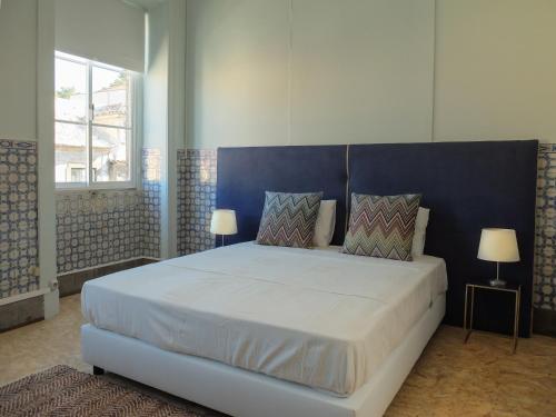 a bedroom with a large bed with a blue headboard at Back to Lisbon Hostel in Lisbon