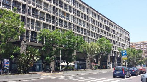 a large building with cars parked in front of a street at B&B Casa Musumeci in Catania