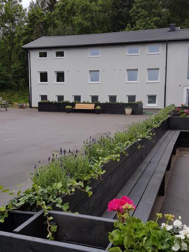 a garden with flowers and a building in the background at Alkoven Logi in Ullared