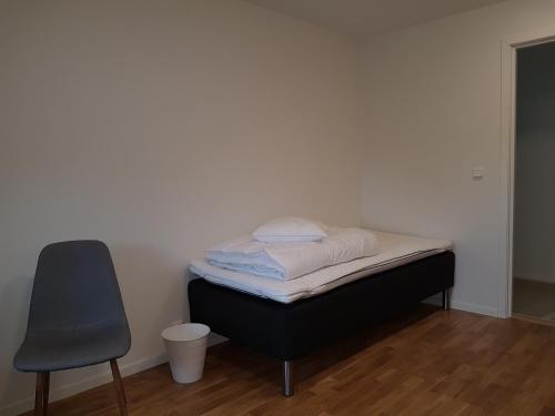 a bed sitting in a room with a chair at Alkoven Logi in Ullared