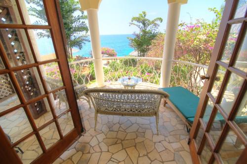 a balcony with a table and a view of the ocean at Catcha Falling Star in Negril