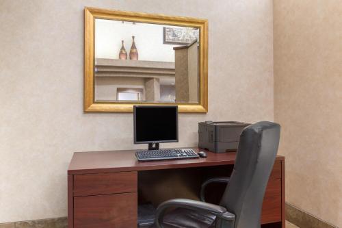 a desk with a computer and a chair in a room at Ramada by Wyndham St George in St. George