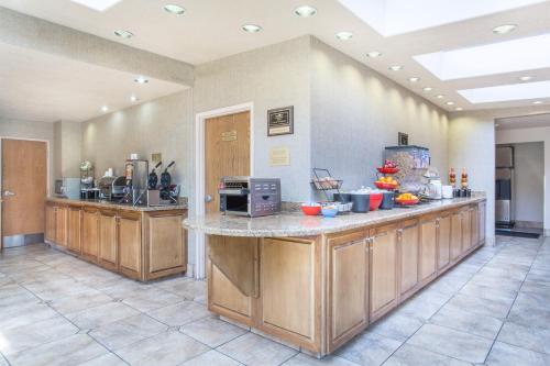 a large kitchen with a counter with a microwave at Ramada by Wyndham St George in St. George