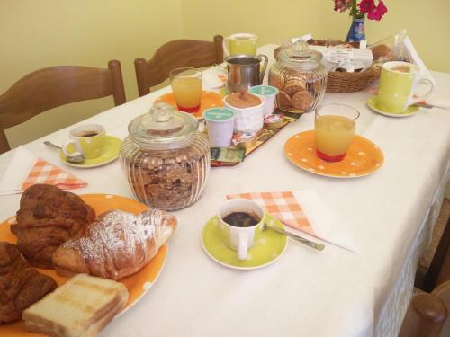 a table with a breakfast of croissants bread and coffee at Julia B&B in Crotone