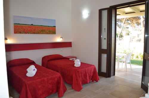 a room with two tables with red table cloths at Podere San Luigi Residence in Otranto