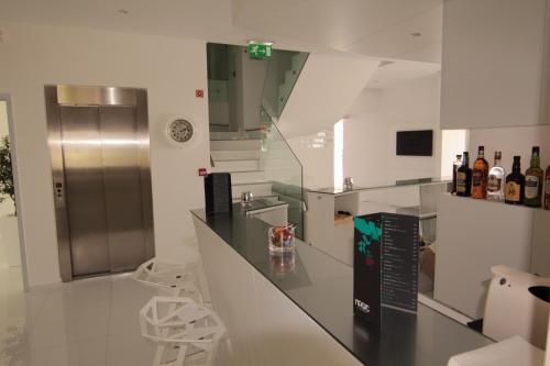 a kitchen with a counter and some bottles of wine at Hotel Magic in Nazaré