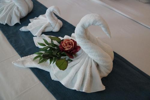 two towel swans sitting on a bathroom floor at Railroad Pass Hotel and Casino Ramada by Wyndham in Boulder City