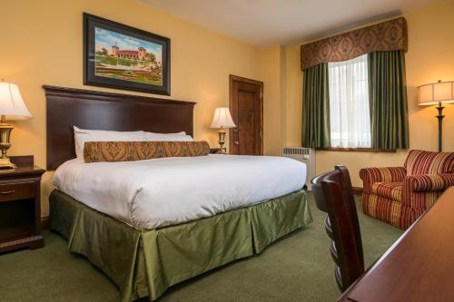 um quarto de hotel com uma cama grande e uma cadeira em Missouri Athletic Club em Saint Louis