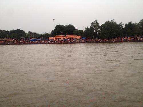 a crowd of people standing on the bank of a river at Patnimal Guesthouse in Haridwār