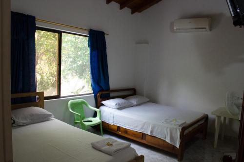 a room with two twin beds and a window at Hospedaje la Glorieta in Santa Fe de Antioquia