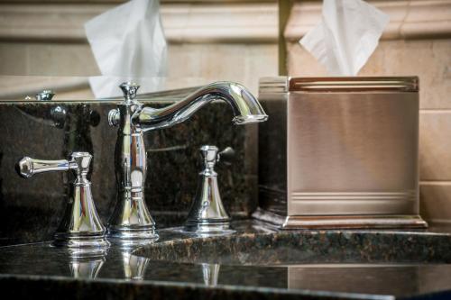 a bathroom sink with a soap dispenser next to it at Missouri Athletic Club in Saint Louis