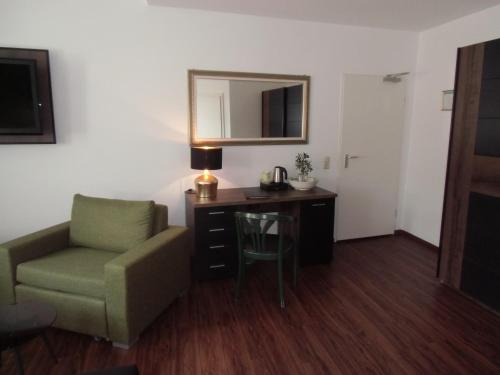 a room with a chair and a desk and a mirror at Hotel Trendtino in Eisenberg