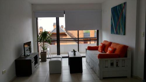 a living room with a couch and a large window at Apartamento Plaza San Martin in Concepción del Uruguay