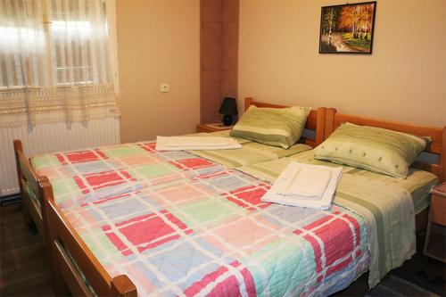 a bedroom with a large bed with two towels on it at Chalet Ljubicine kolibe in Golubinje