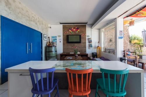 une cuisine avec des chaises colorées autour d'un comptoir dans l'établissement Babilonia Rio Hostel, à Rio de Janeiro
