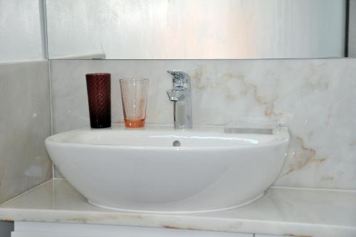 a bathroom sink with a glass and a faucet at Sleep In Bucelas in Bucelas