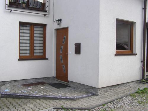 a door of a white building with a window and a door at Apartament pod Nosalem in Zakopane