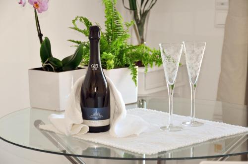 a bottle of wine sitting on a glass table with two glasses at Sleep In Bucelas in Bucelas