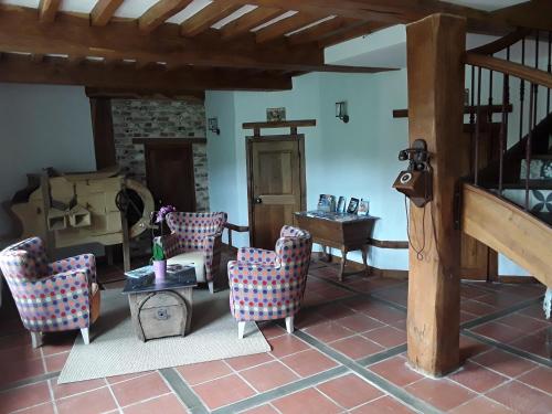 a living room with chairs and a table at Au Moulin de Valérie in Frencq