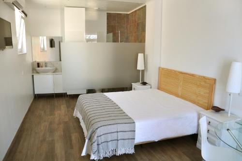 a white bedroom with a bed and a bathroom at Sleep In Bucelas in Bucelas