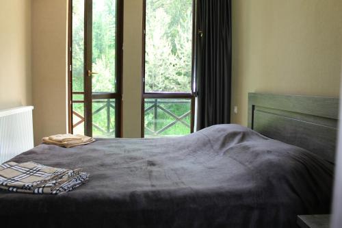 a bed in a room with a large window at Bakuriani Residence 165 in Bakuriani