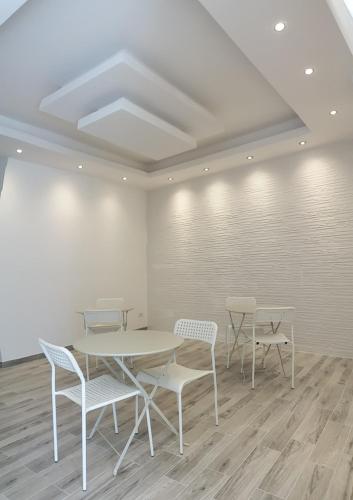 a room with tables and chairs and a white wall at Diana's in Stintino