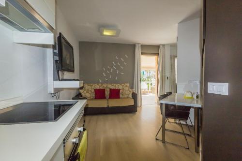 a kitchen and a living room with a couch at TRG Studio in Arona